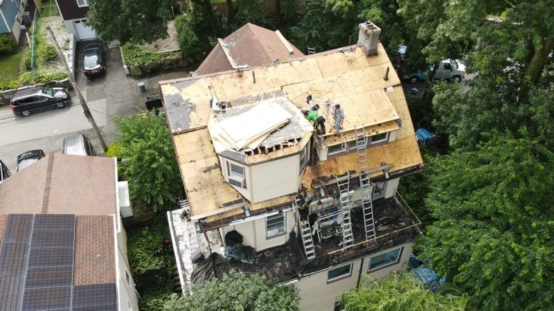 An aerial view of a house undergoing a roof replacement.