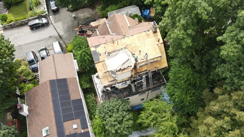 An aerial view of a house with a solar panel on the roof.