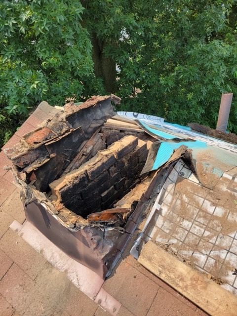 A roof with a hole in it and a tree in the background