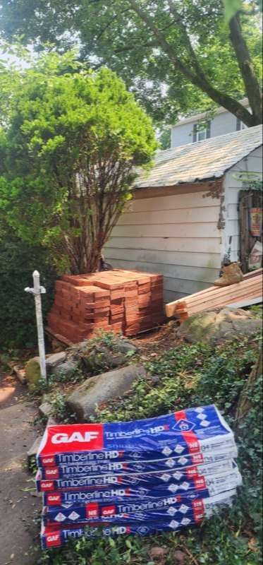 A stack of bricks is sitting in front of a garage.