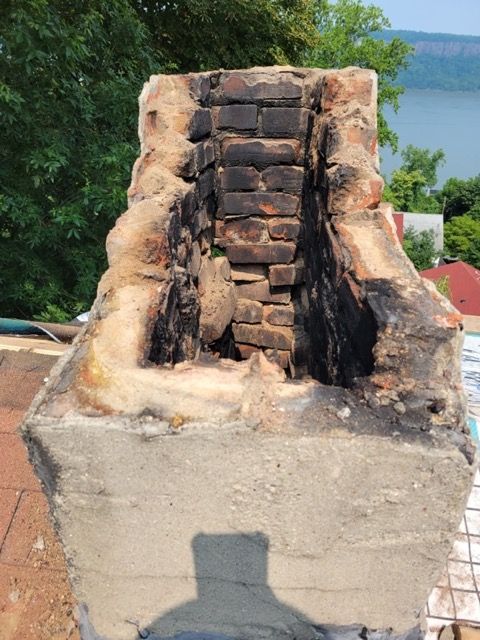 A brick chimney with a shadow of a person on it