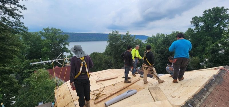 A group of people are standing on top of a wooden roof.