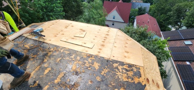 A man is working on the roof of a house.