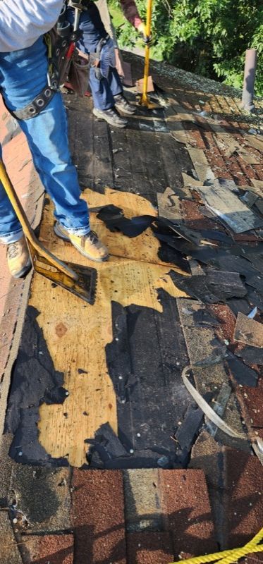 A man is cleaning a roof with a broom.