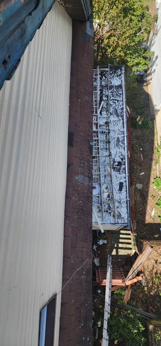 An aerial view of a building with a roof that is covered in snow.