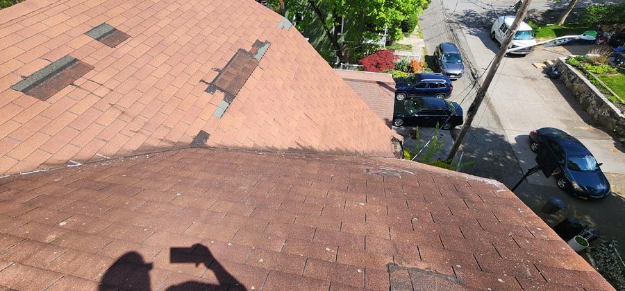 A person is taking a picture of a roof with a camera.