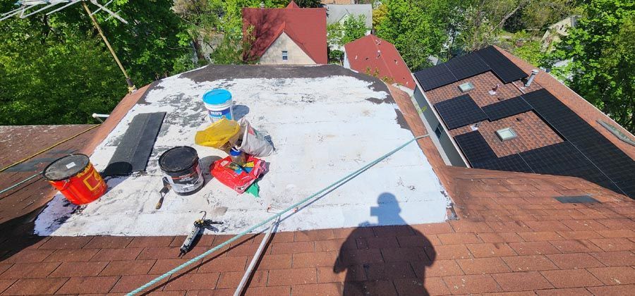 An aerial view of a roof with buckets of paint on it.