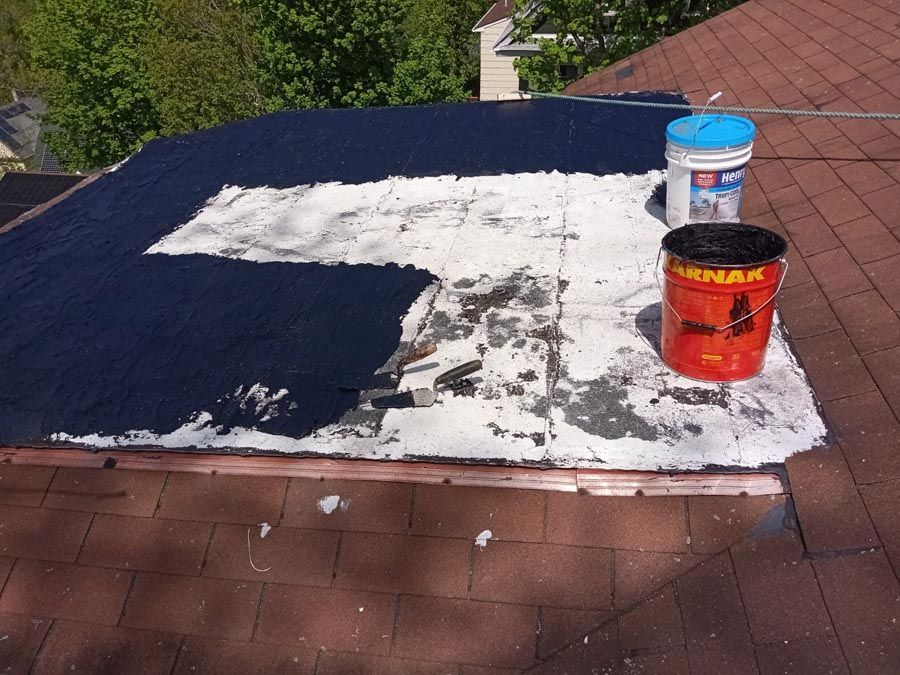 Two buckets of paint are sitting on top of a roof