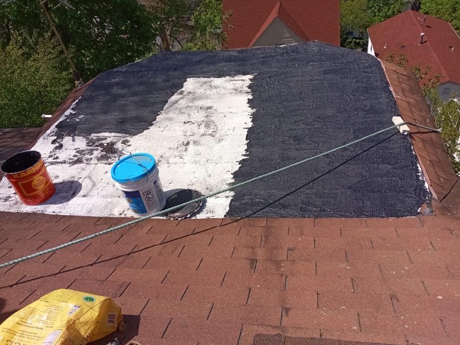 Two buckets of paint are sitting on top of a roof.