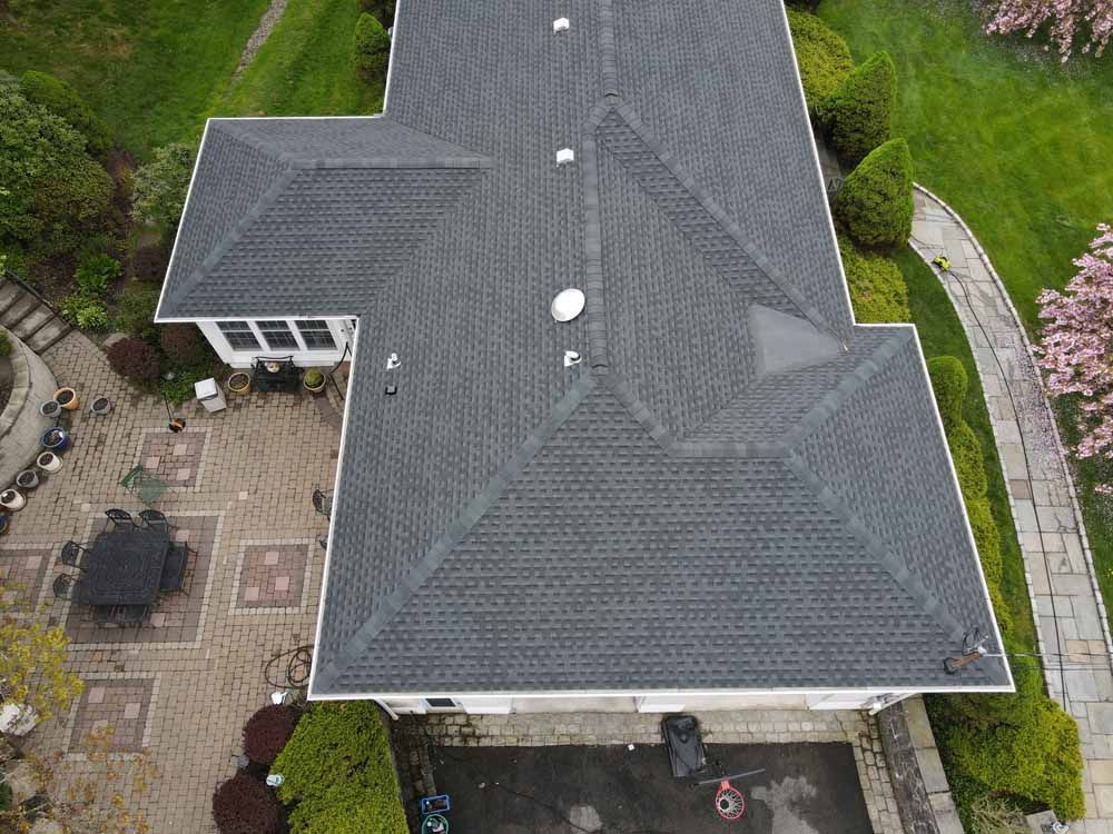 An aerial view of a large house with a roof and a patio.