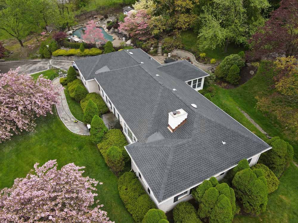 An aerial view of a large house surrounded by trees and bushes.