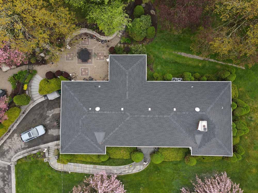 An aerial view of a large house with a car parked in front of it.