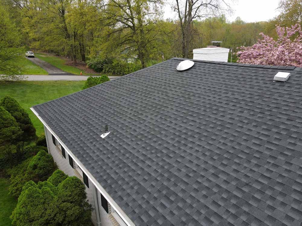 An aerial view of a house with a black roof.