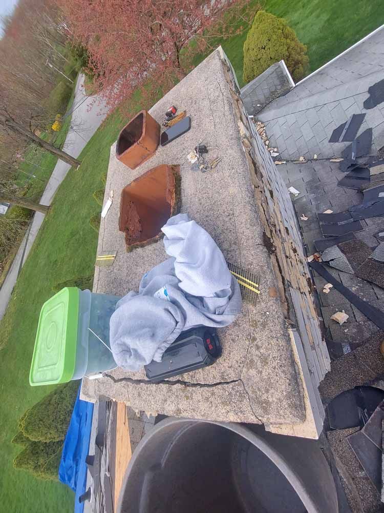 A chimney is being repaired on the roof of a house.