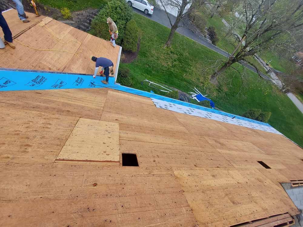 A group of people are working on a wooden roof.