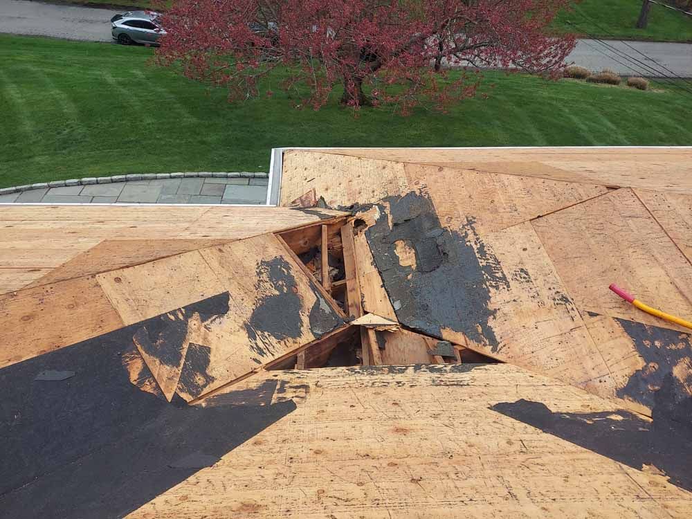 A roof with a hole in it and a pencil on it.