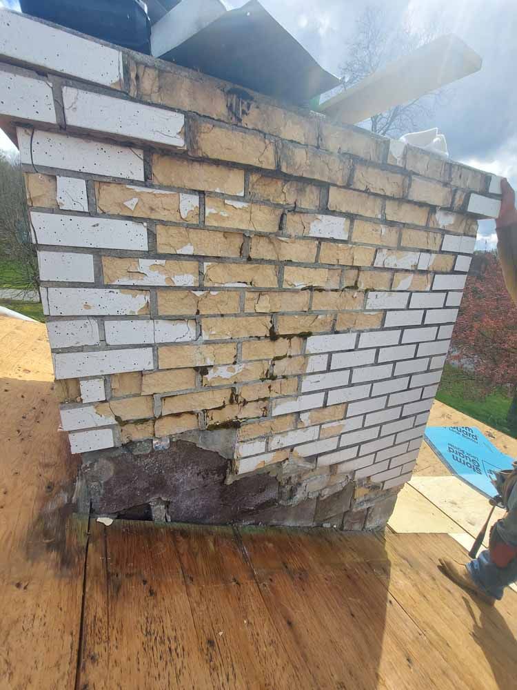 A brick chimney is sitting on top of a wooden deck.