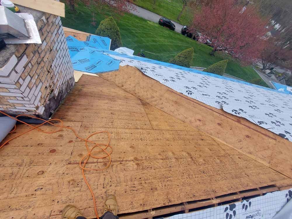 The roof of a house is being remodeled and a chimney is being removed.