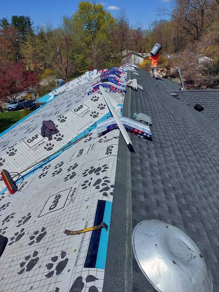 A roof with a lot of shingles being installed on it.