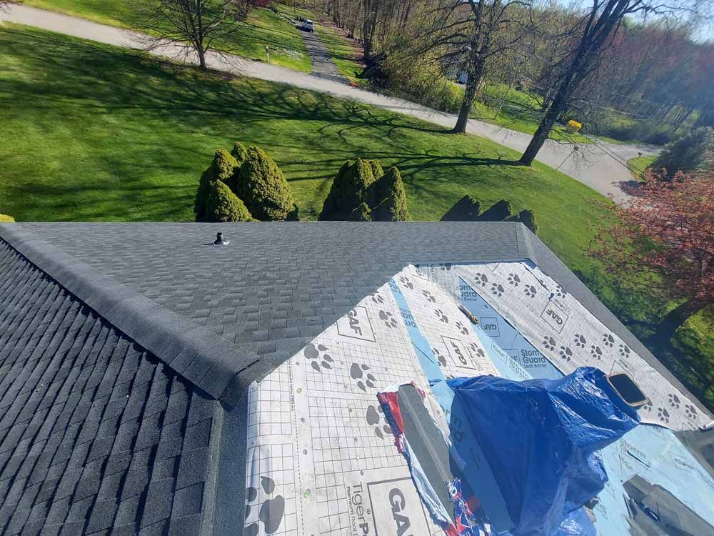 An aerial view of a roof with a blue tarp on it.