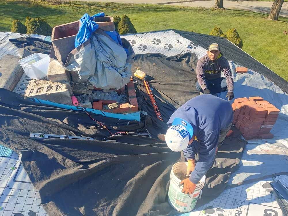 Two men are working on the roof of a house.