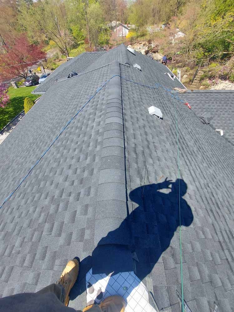 A person is standing on the roof of a house.