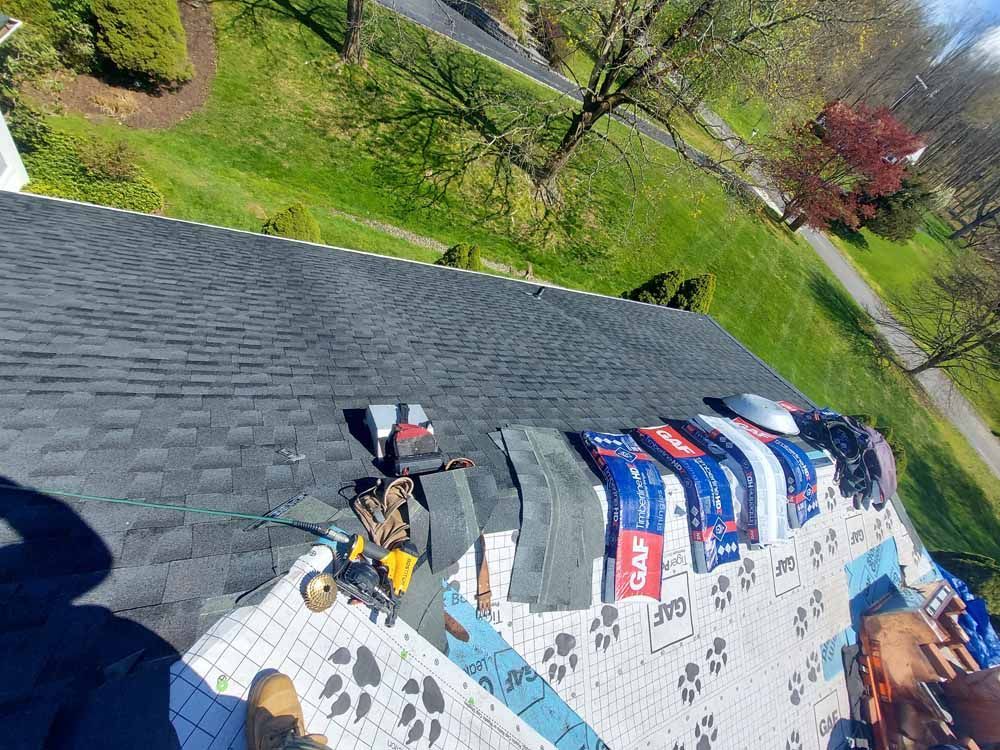 A person is standing on the roof of a house.