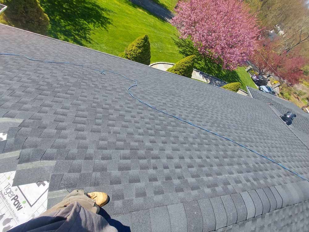 A person is standing on the roof of a house.