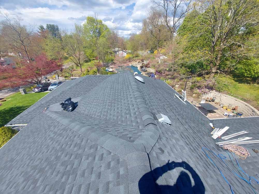 An aerial view of a roof with a shadow of a person on it.