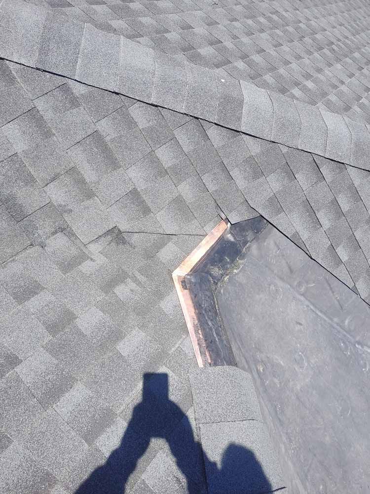 A person is taking a picture of a roof with a cell phone.