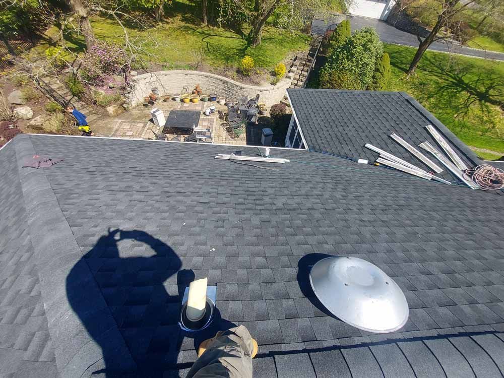 A person is standing on the roof of a house.