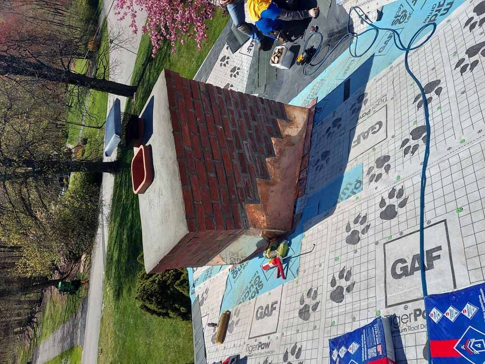 A group of people are working on a brick chimney.