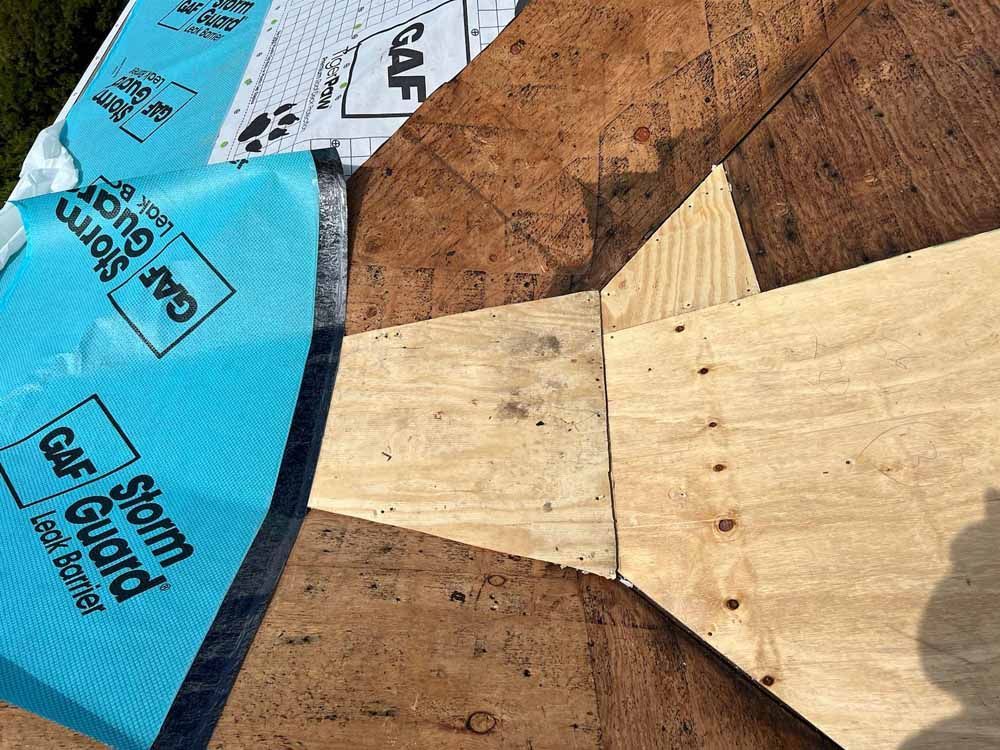 A piece of plywood is sitting on top of a wooden roof.