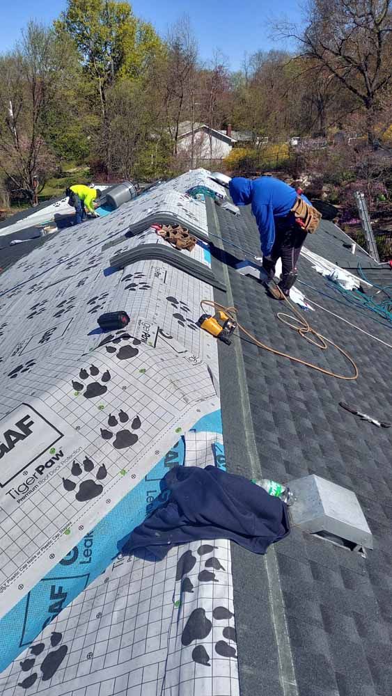 A man is working on the roof of a house.