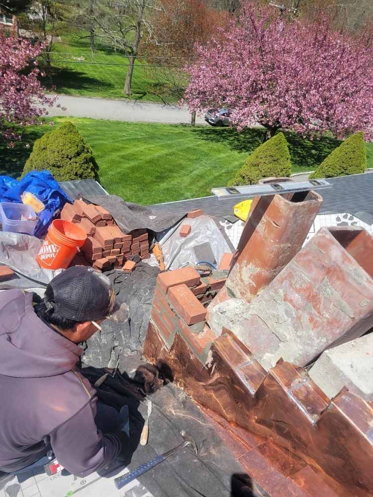 A man is working on the roof of a house.