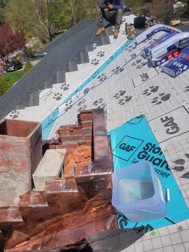 A man is sitting on the roof of a house.