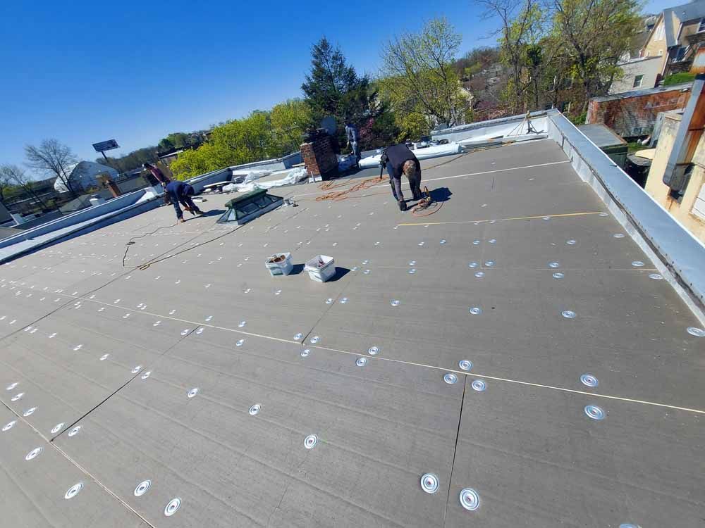 A group of people are working on the roof of a building