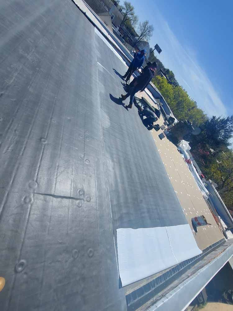 A group of people are standing on top of a roof.