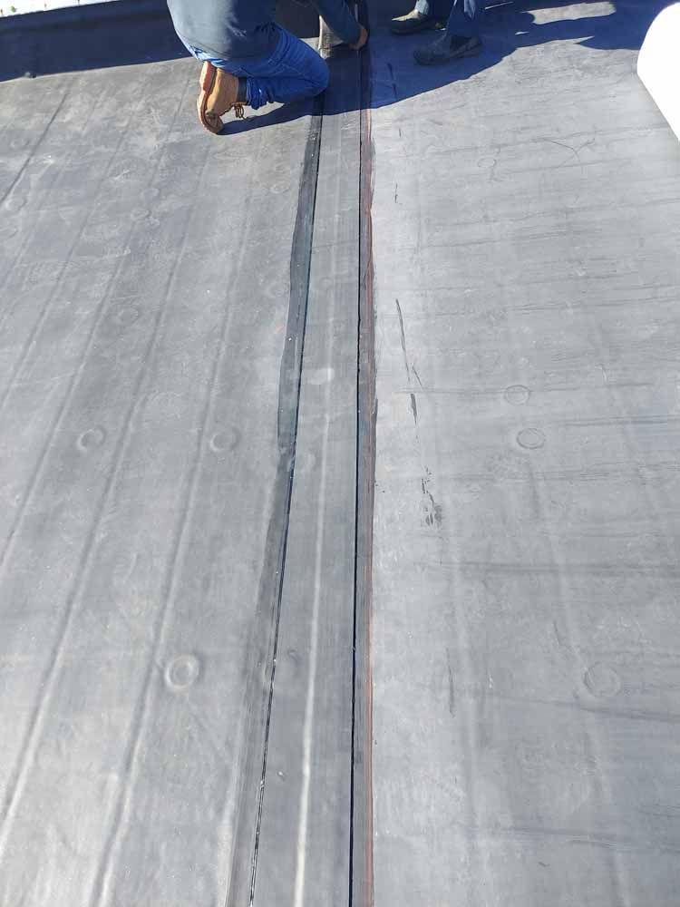 A person is standing on a roof with a black line on it.