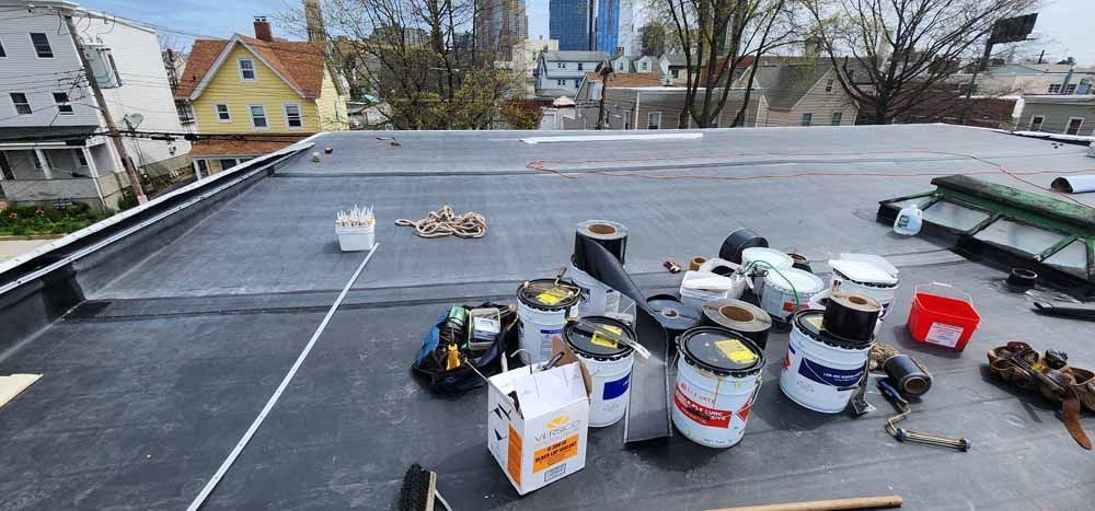 A roof with a lot of buckets and boxes on it.