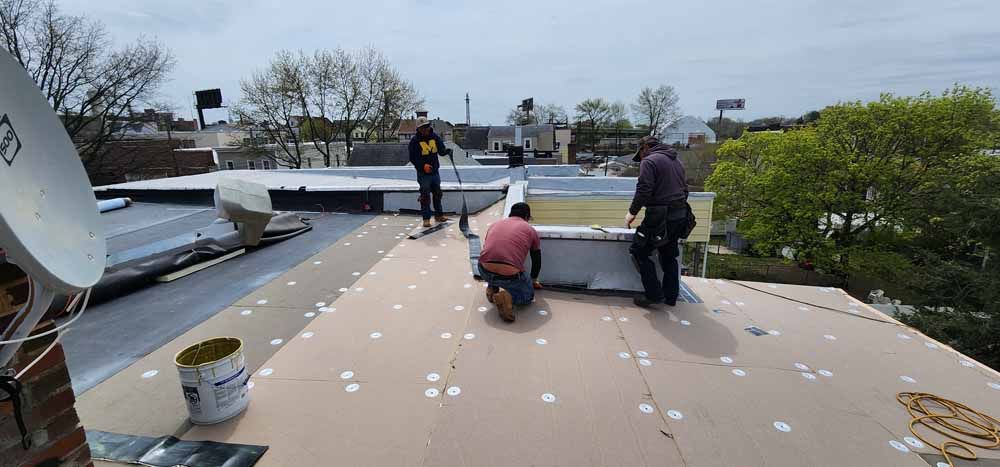 A group of men are working on a roof.