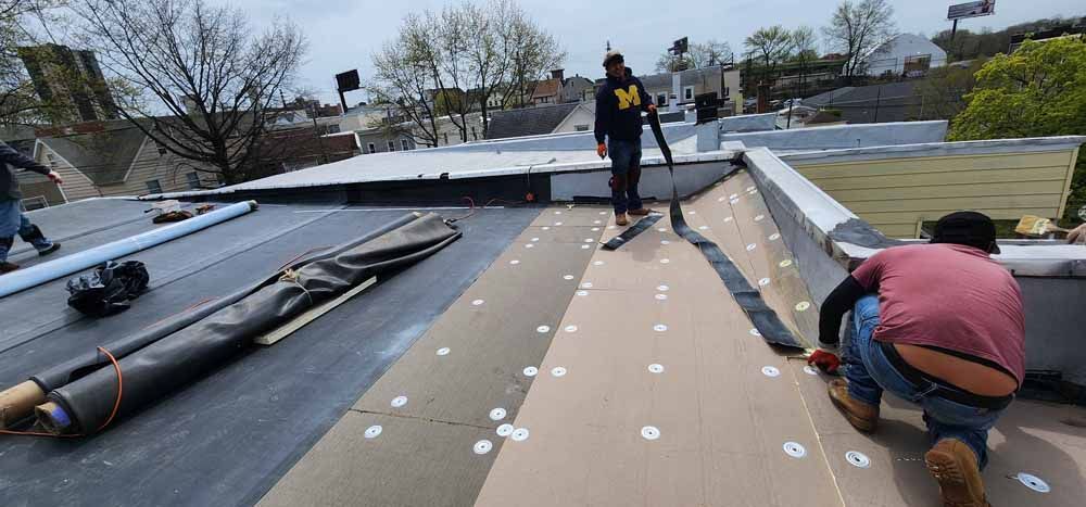 A group of men are working on a roof.