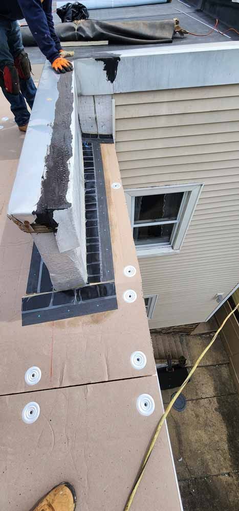 A man is working on the roof of a house.