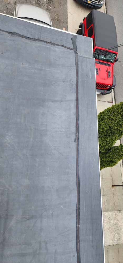 A red truck is parked on the side of a building.