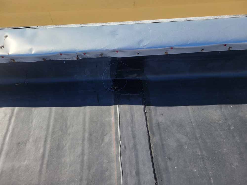 A close up of a roof with a drain on it.