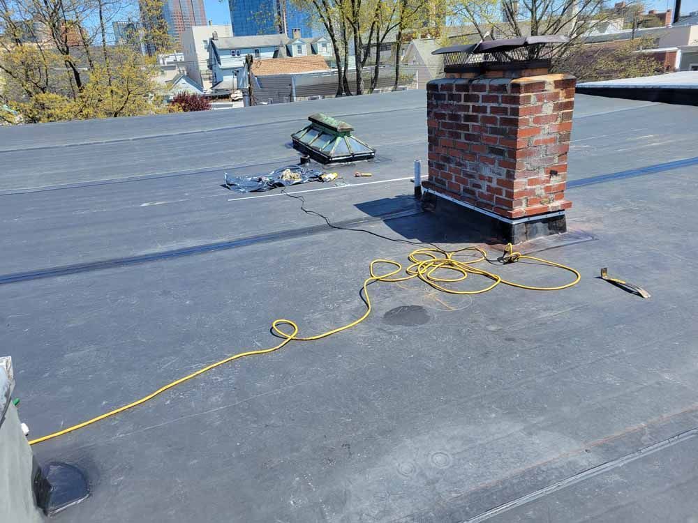 There is a brick chimney on the roof of a building.