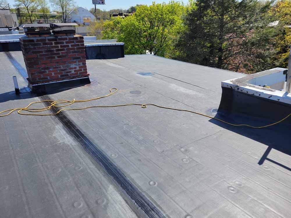 A black roof with a chimney on top of it.