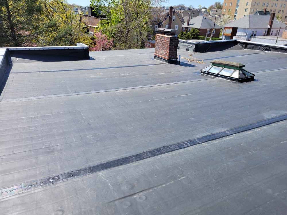 A roof with a chimney and a skylight on it.