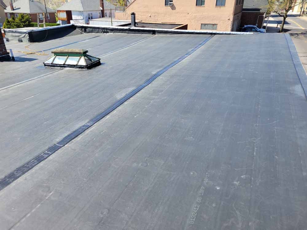 A black roof with a skylight on top of it.