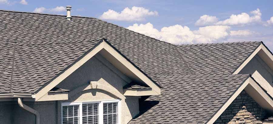 The roof of a house with a gray shingle roof